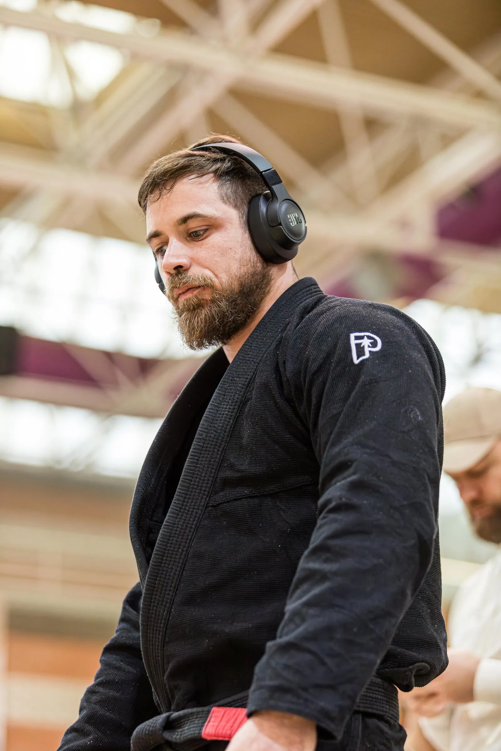 Jérôme Martinez en kimono noir, casque audio sur les oreilles, avant un combat